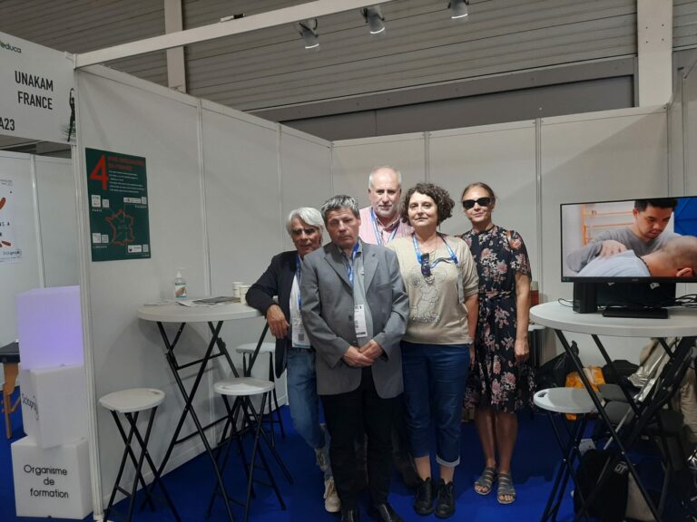 Stand de l'UNAKAM avec au 1er plan Joël et Corinne et au 2ème plan Joachim Fabrice et Nathalie ! A droite il ya un écran vidéo qui diffuse des prises de vues des écoles IFMKDV